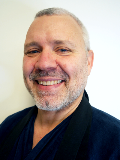 Lenke til studentbuddhist. Foto av mann med sort drakt. 