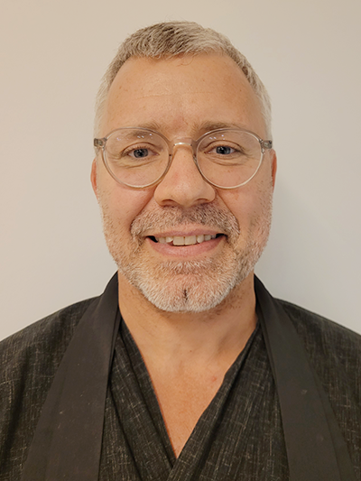 Link to the Buddhist chaplain. Photo of a man in a black robe.